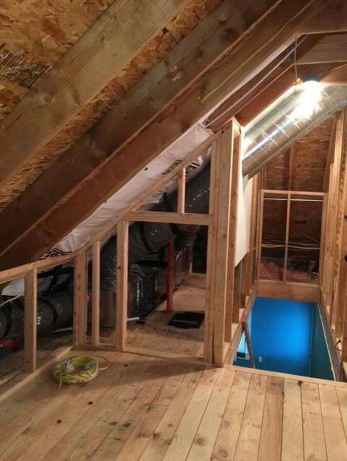Residential remodel in process showing open walls and wood floors